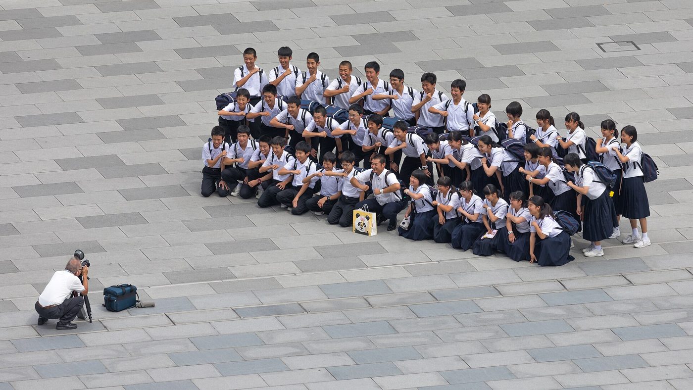 Photographer taking a group photograph of smiling students in front of the Tokyo station, Marunouchi, Japan.jpg